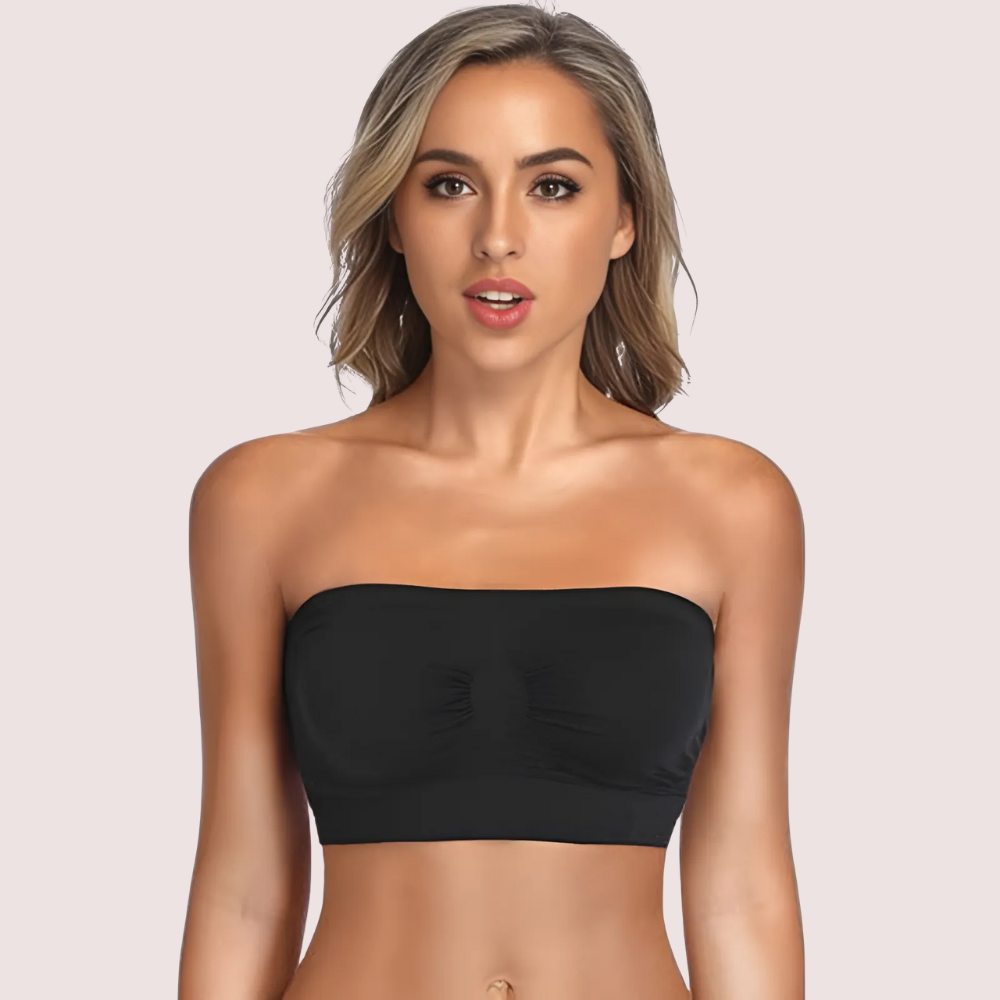 Woman wearing a black strapless top against a light pink background