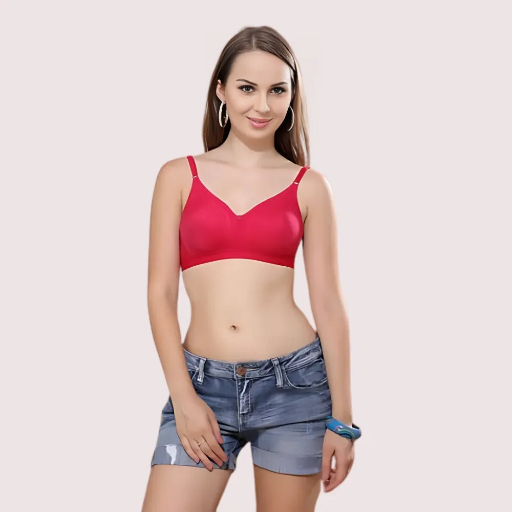 Woman wearing a red bralette and denim shorts on a light pink background