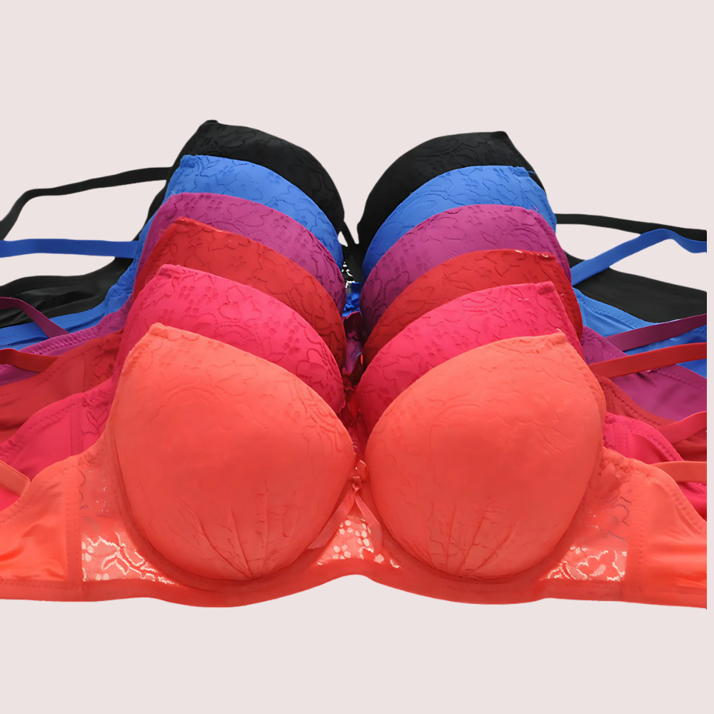 Stack of colorful bras on a light gray background