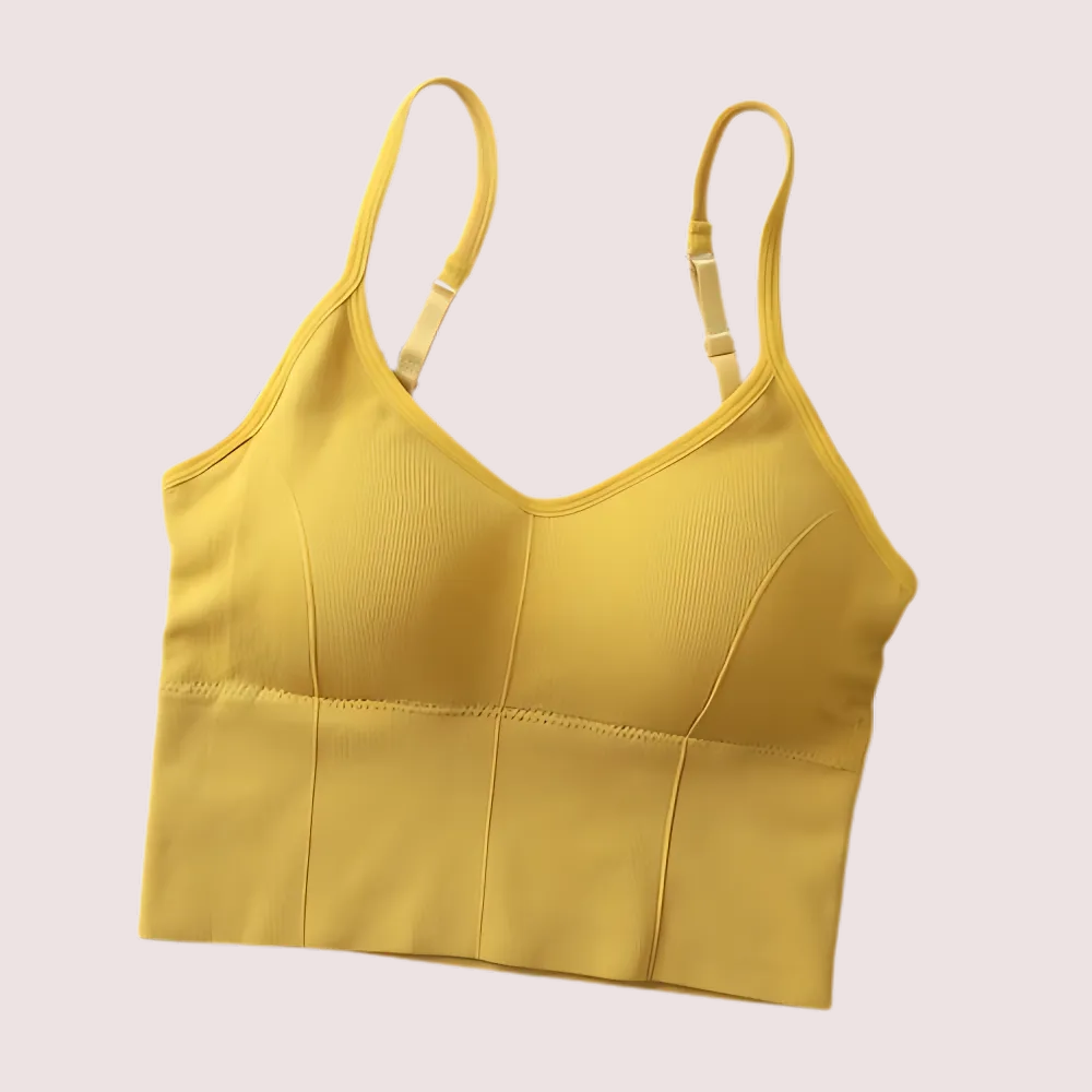 Yellow crop top with thin straps on a light beige background
