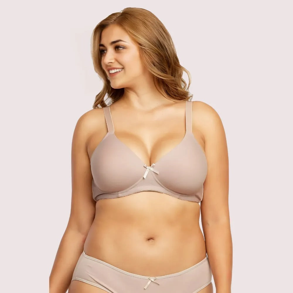 Woman wearing a beige bra and underwear set on a light pink background