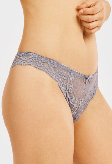 Lace underwear worn by a person on a plain background