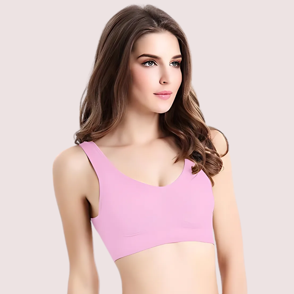 Woman wearing a pink bralette against a plain background