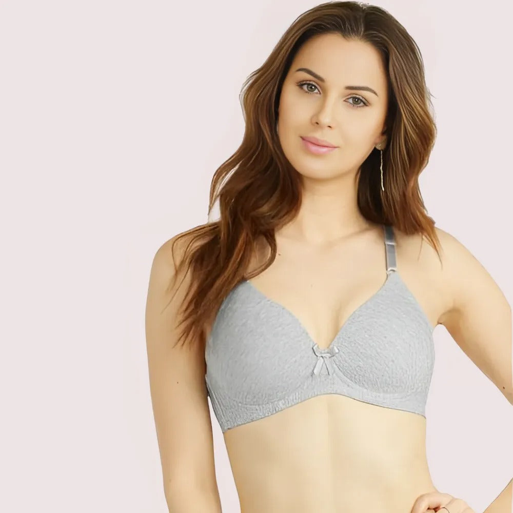 Woman wearing a gray bra against a light pink background