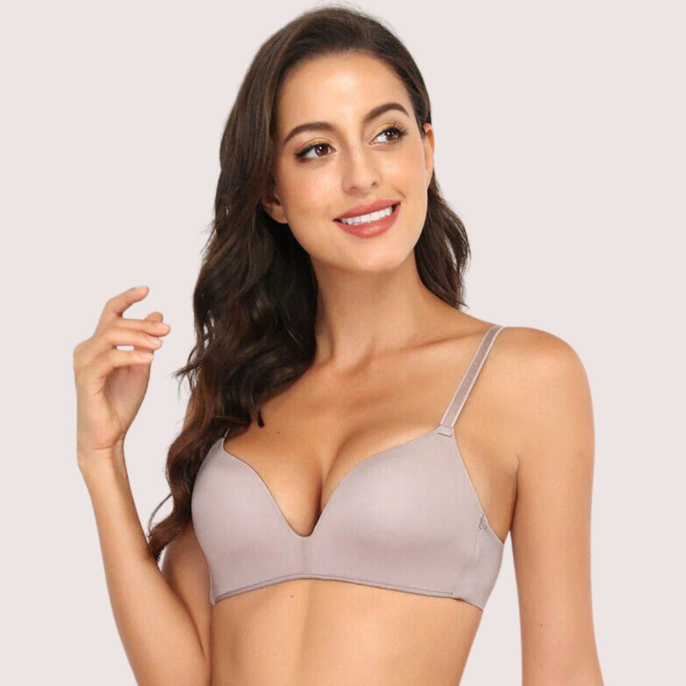 Woman wearing a beige bra against a plain background