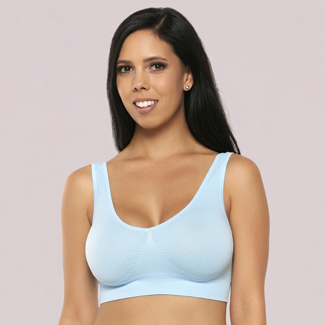 Woman wearing a light blue sports bra against a plain background