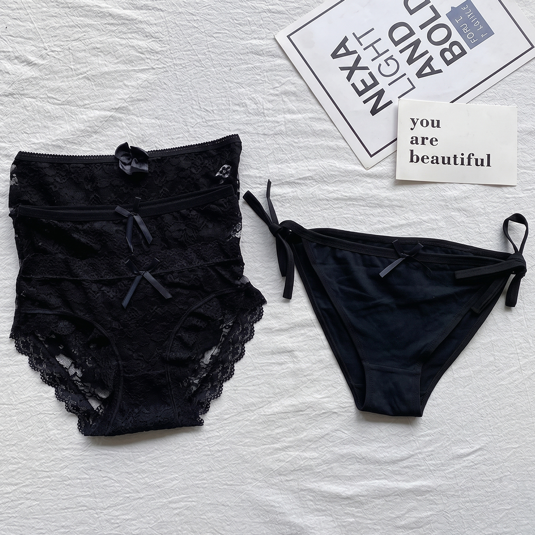 Black lace lingerie set on a textured surface with motivational cards.