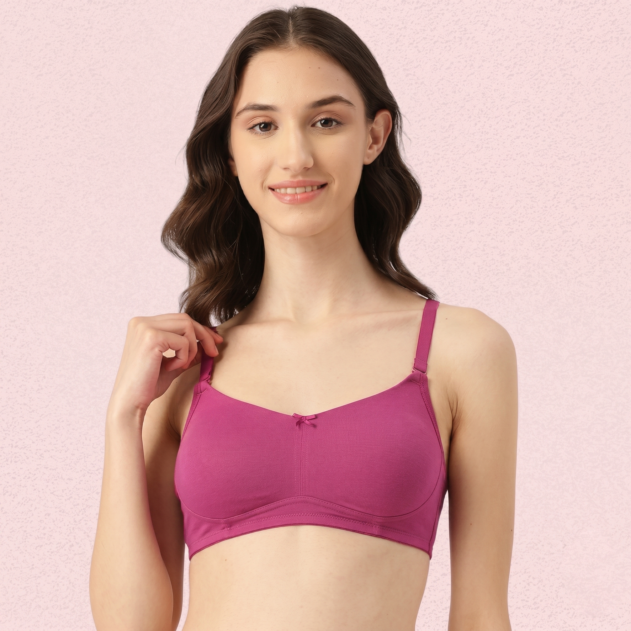 Woman wearing a pink bra against a pink background