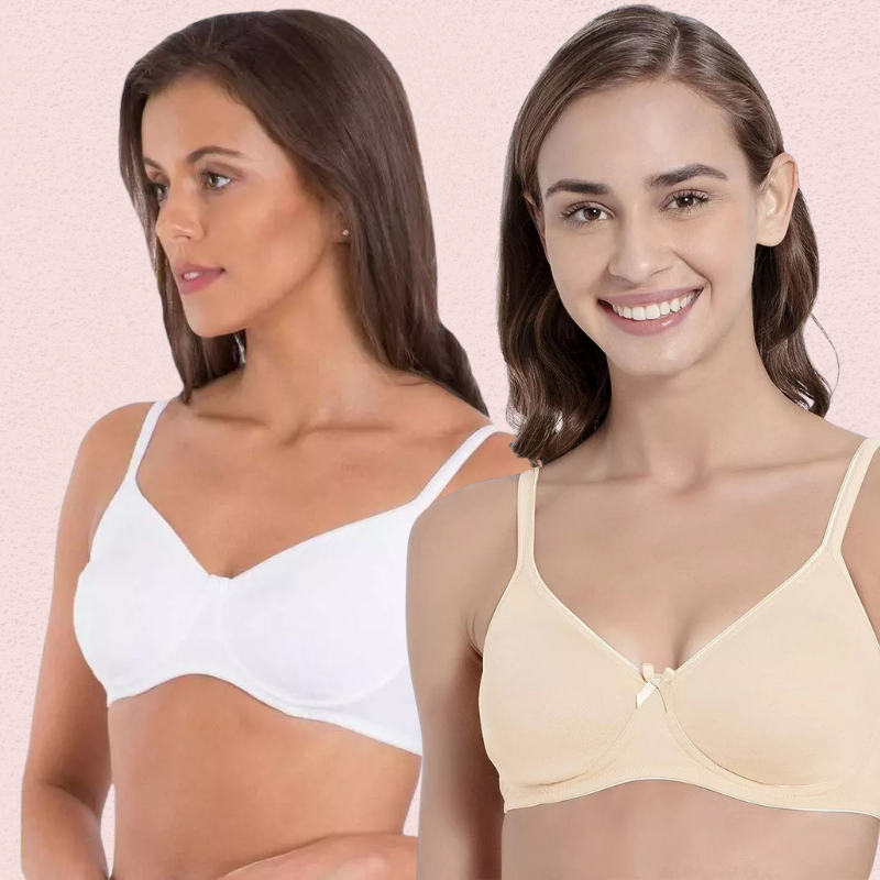 Two women wearing white and beige bras against a pink background