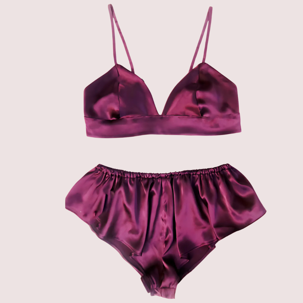 Purple satin lingerie set on a beige background