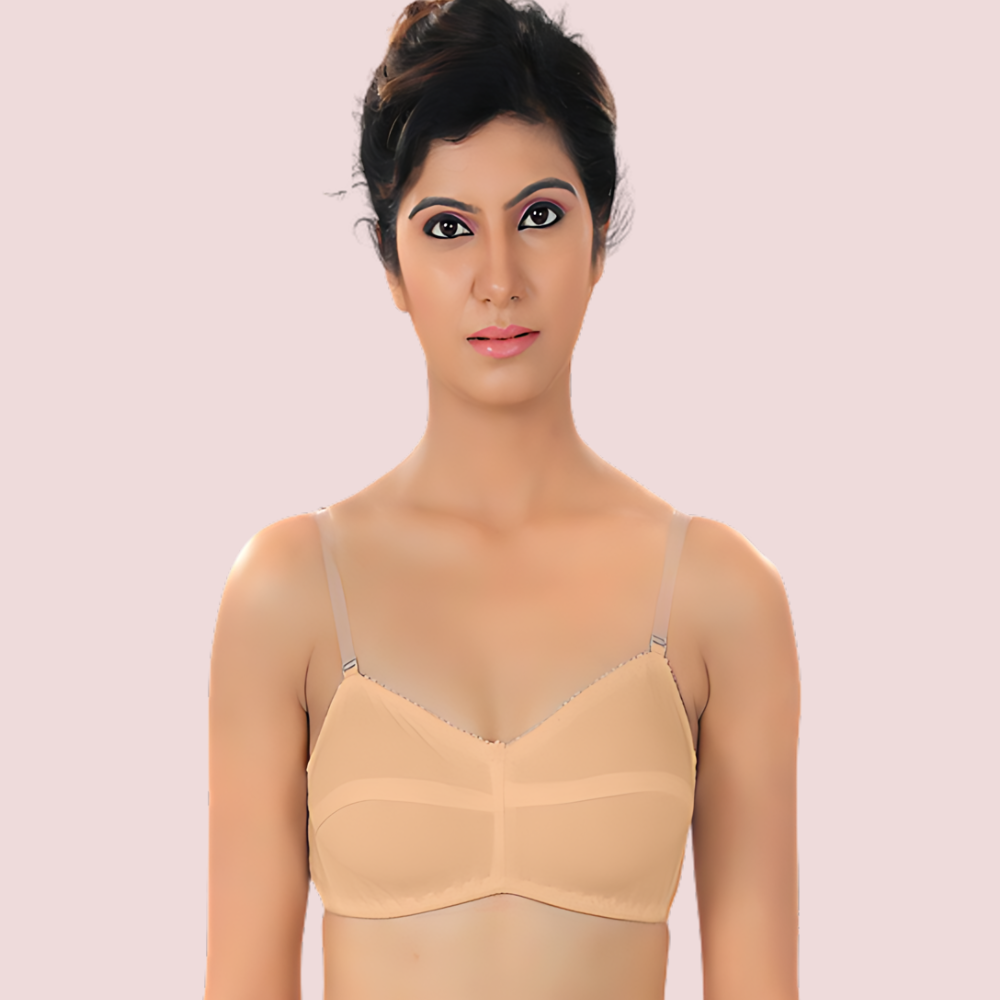 Woman wearing a beige bralette against a light pink background