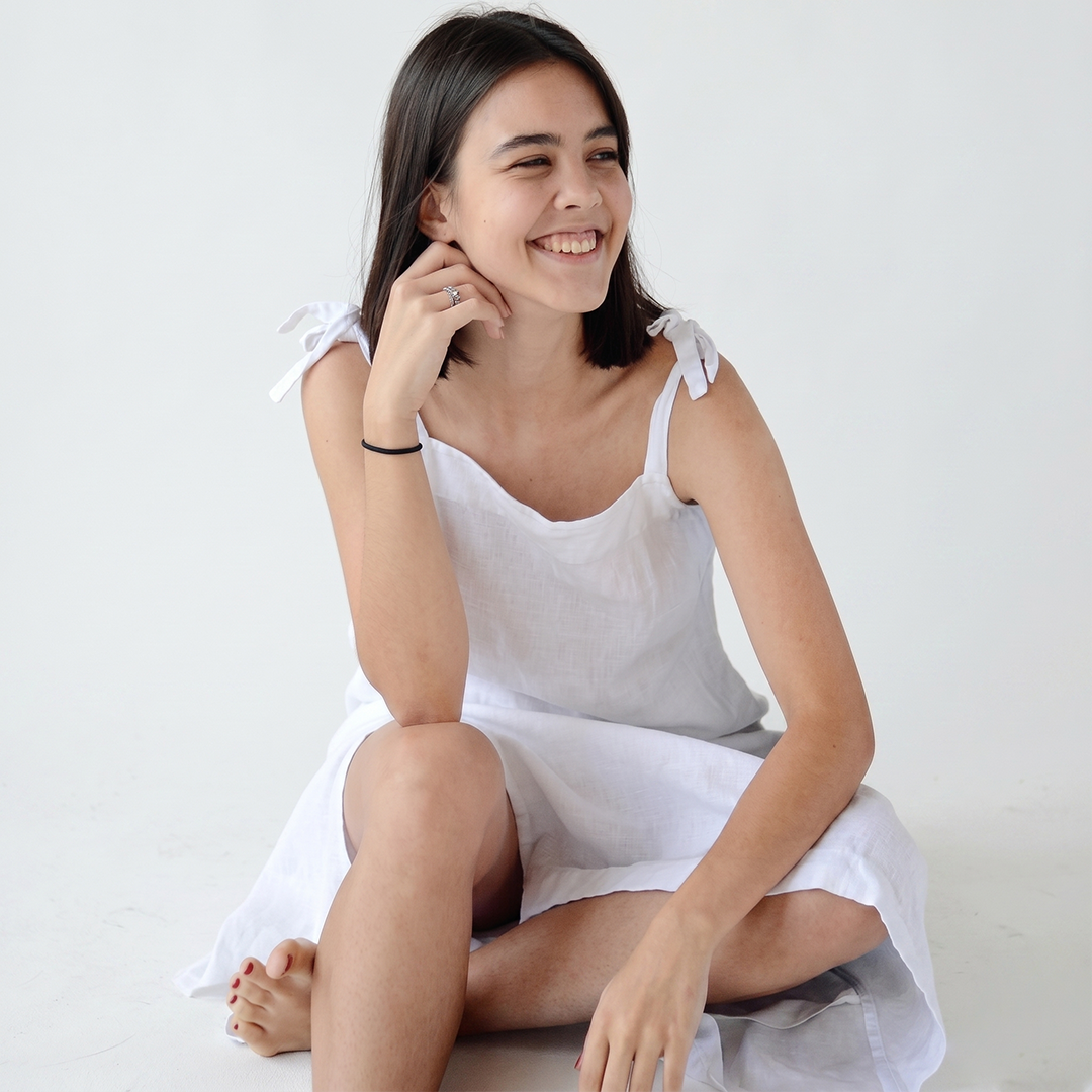 Woman in a white dress sitting on a white background