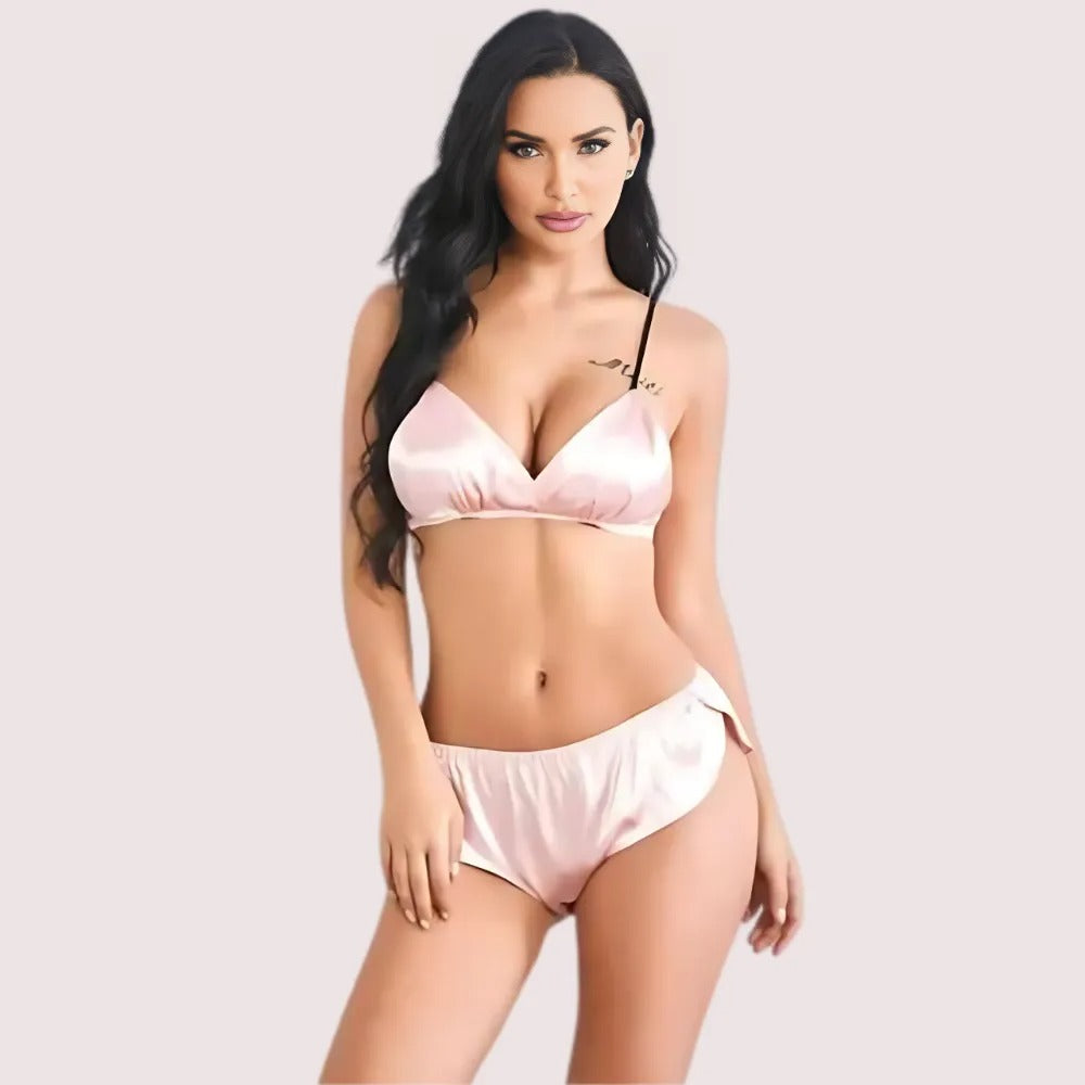 Woman wearing a pink satin bikini set on a plain background