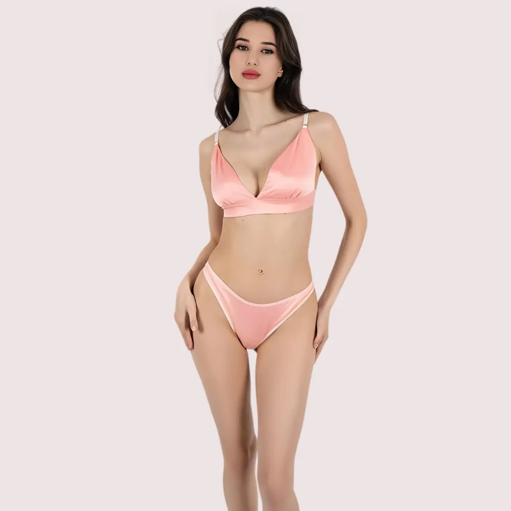 Woman wearing a pink bikini set on a light pink background