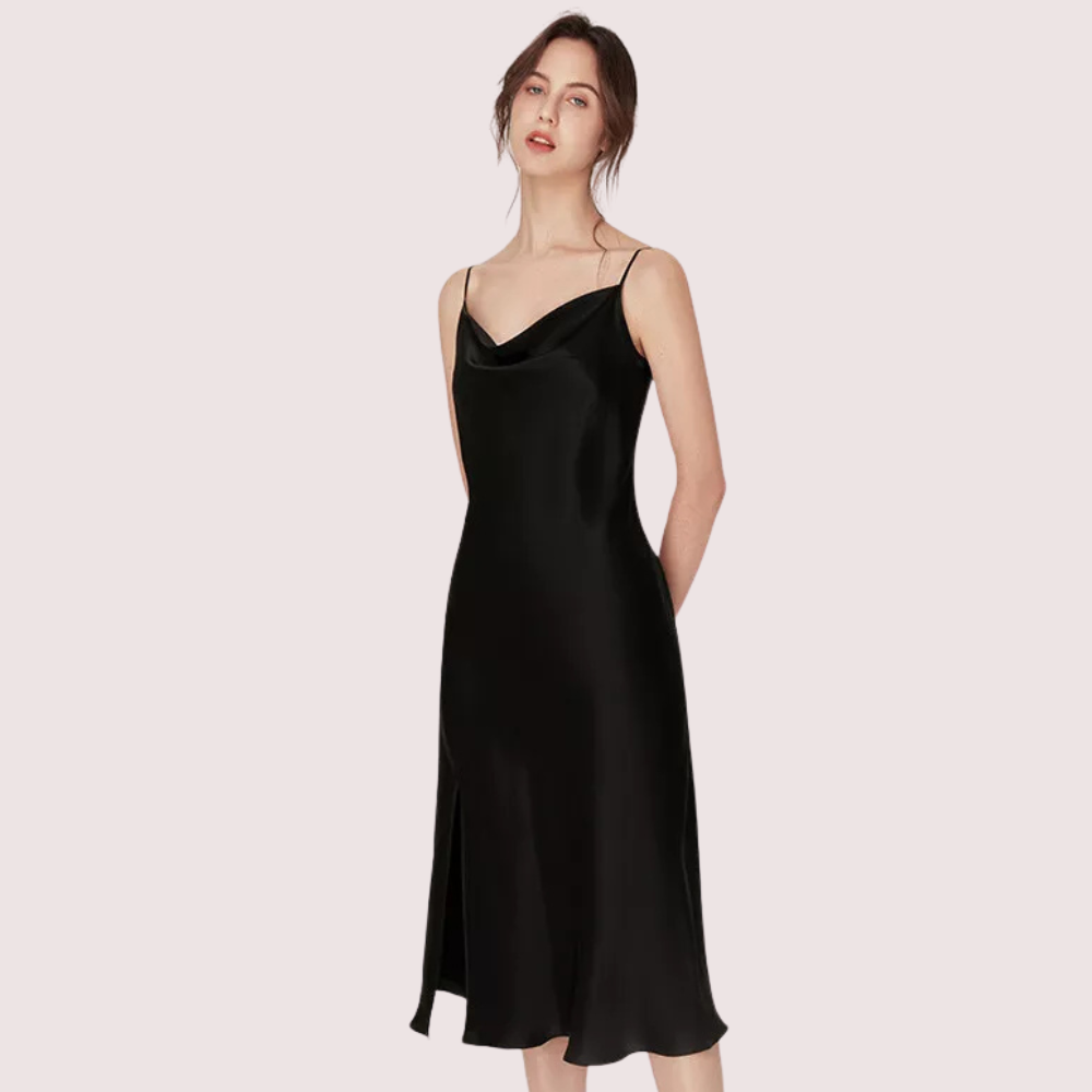 Black slip dress worn by a model on a light pink background