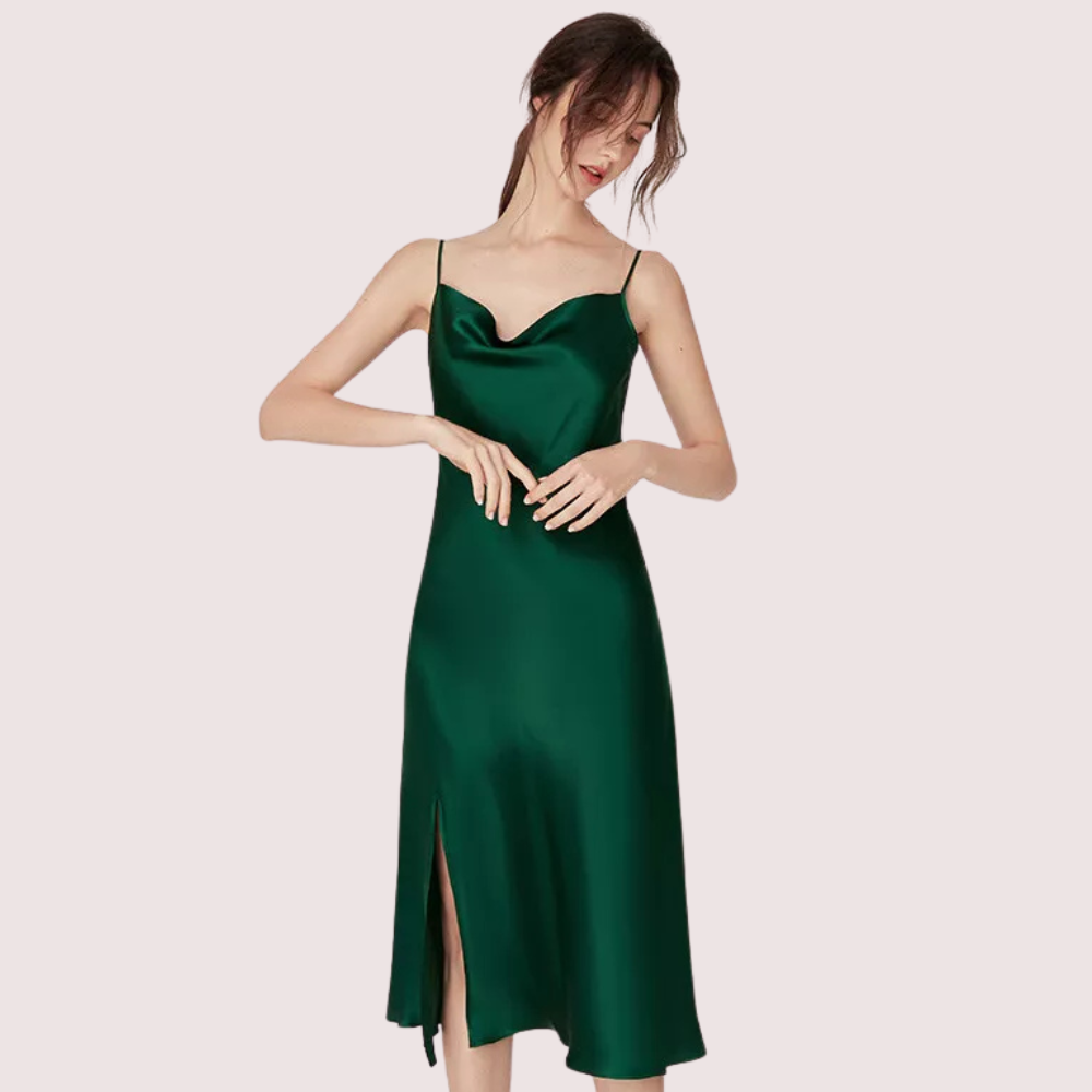 Woman wearing a green satin dress on a light pink background