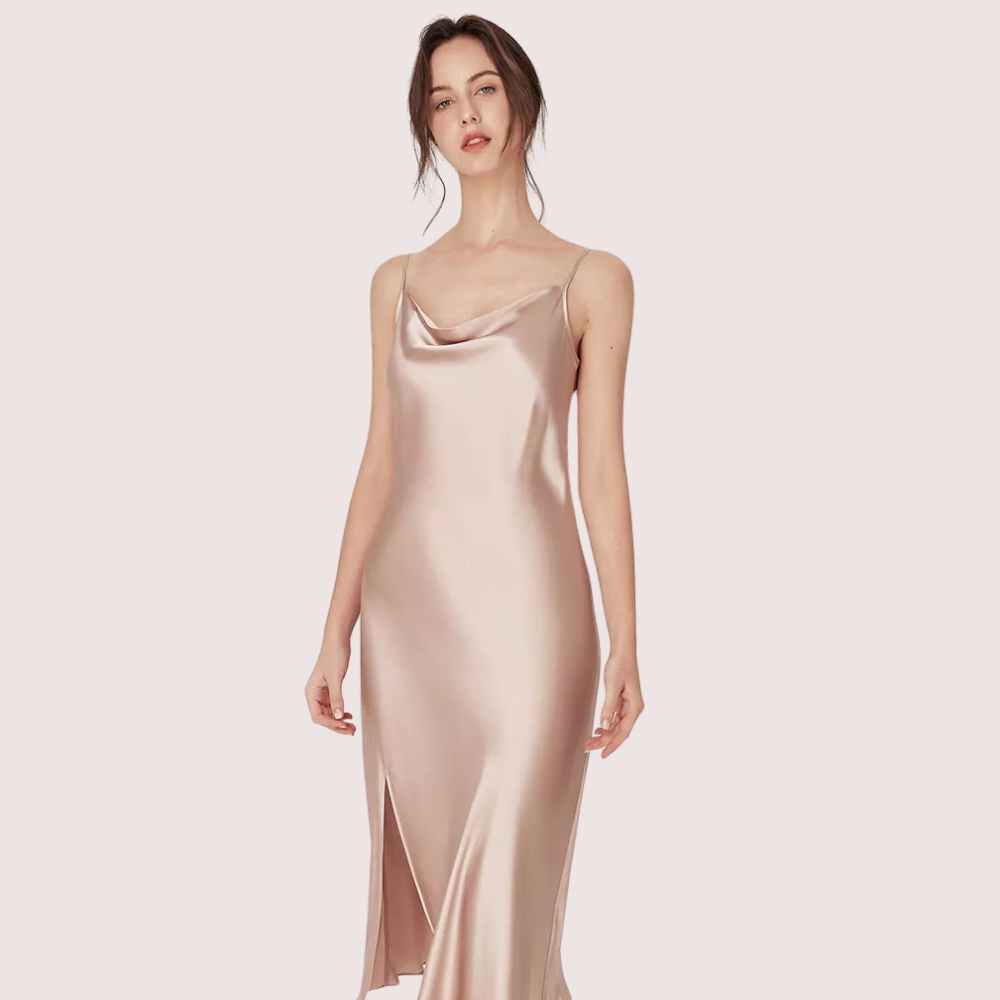 Woman wearing a satin slip dress on a light pink background