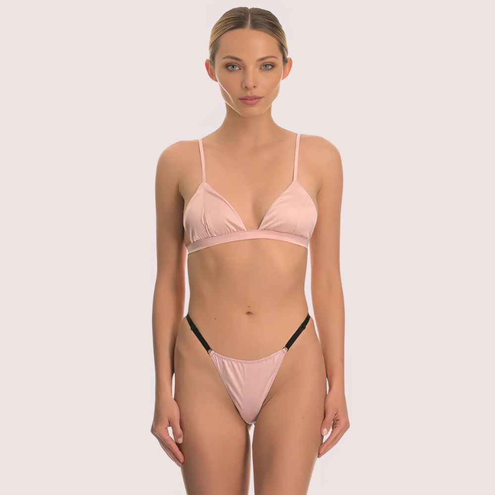 Woman wearing a pink bikini set on a plain background