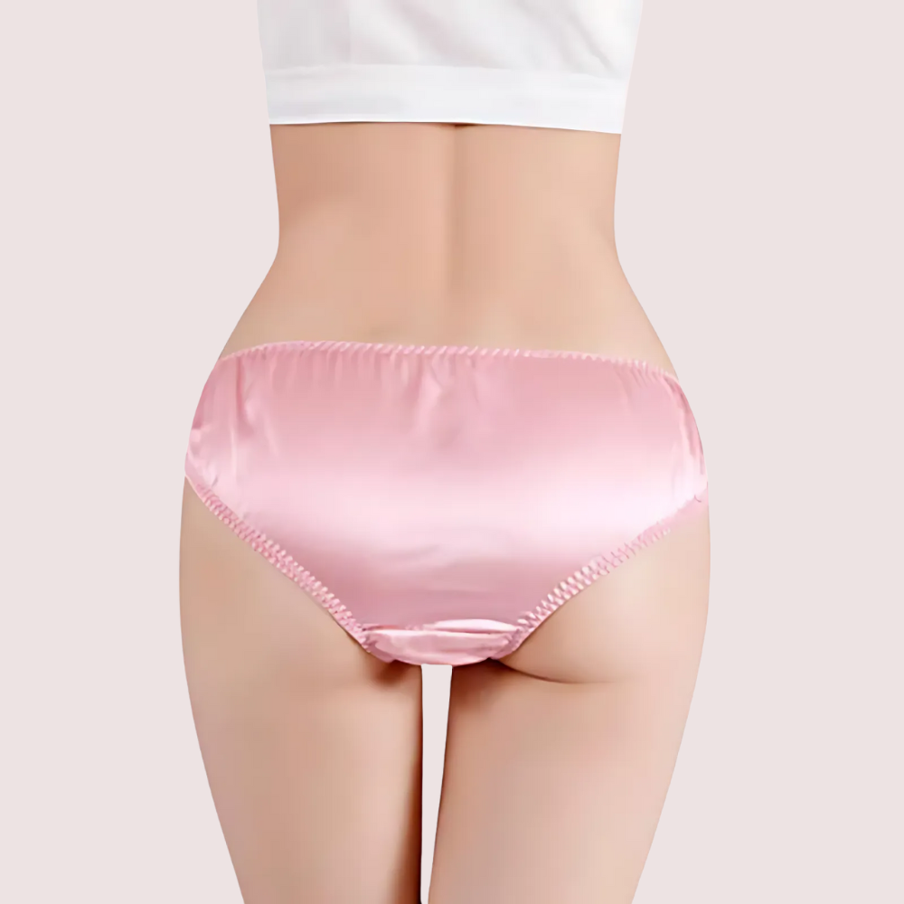 Person wearing pink satin underwear on a plain background