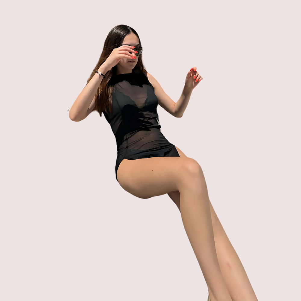 Woman wearing a black sheer outfit on a plain background