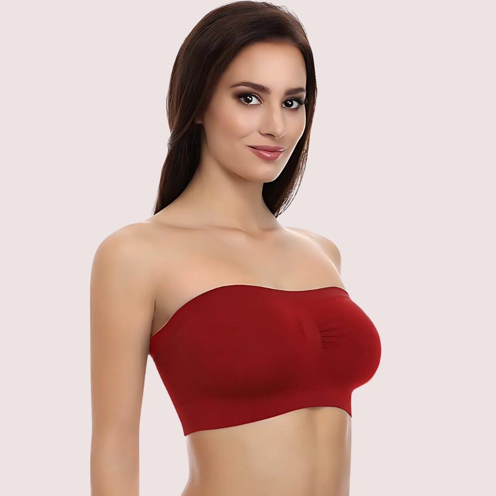 Woman wearing a red strapless top against a plain background