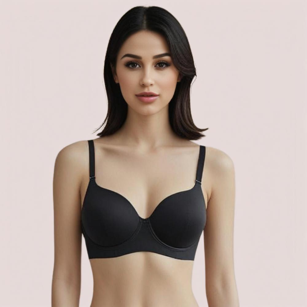 Woman wearing a black bra against a light pink background