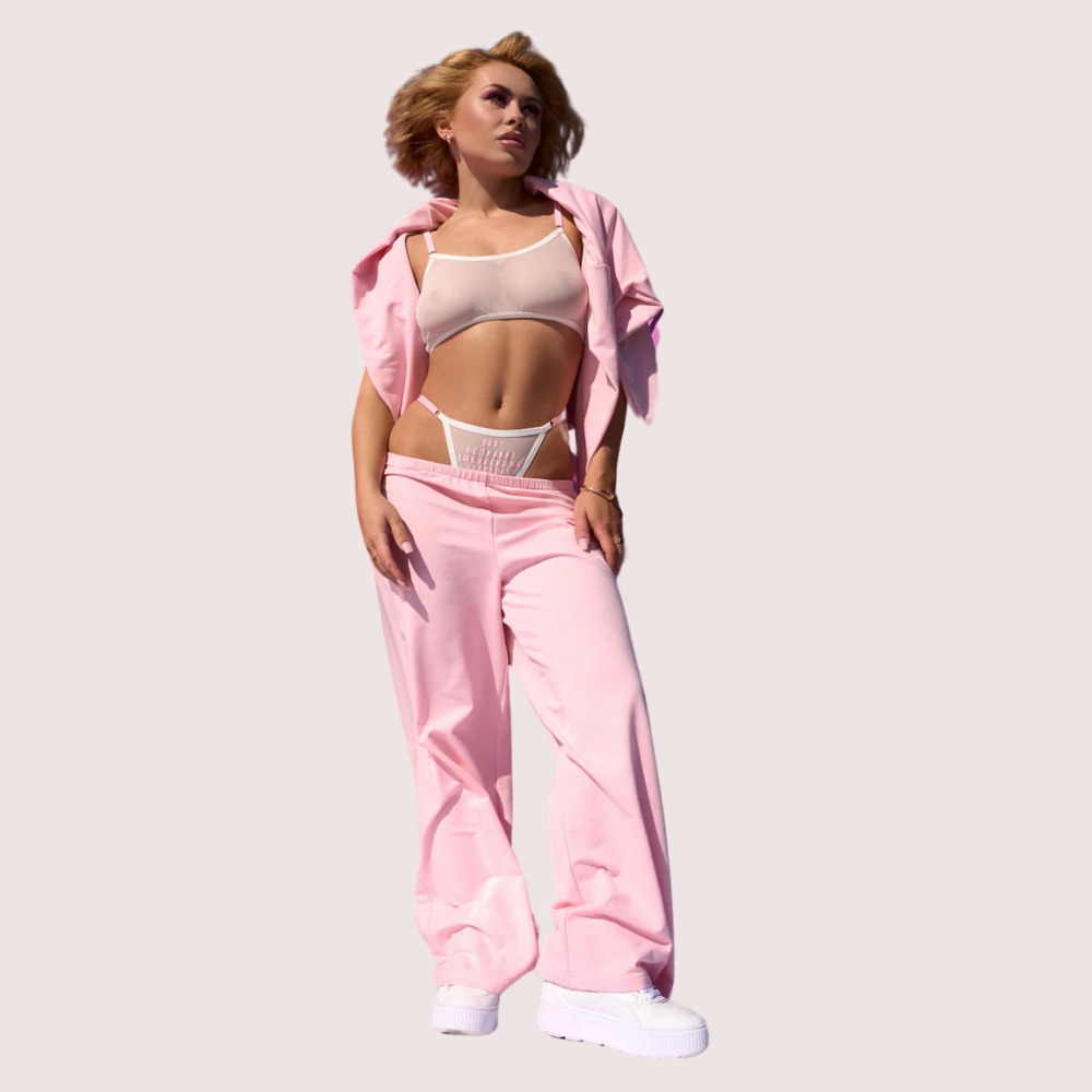Person wearing a pink tracksuit with a plain background