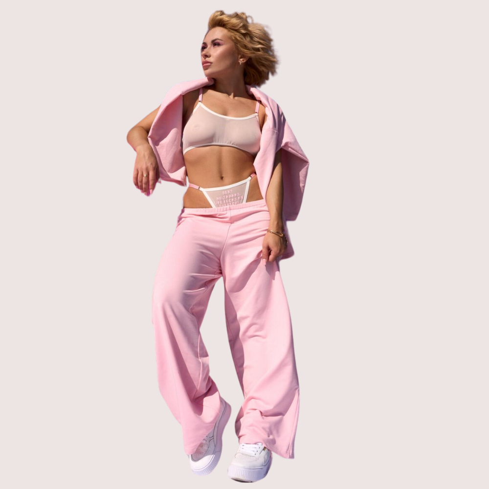 Person wearing a pink outfit with a plain background