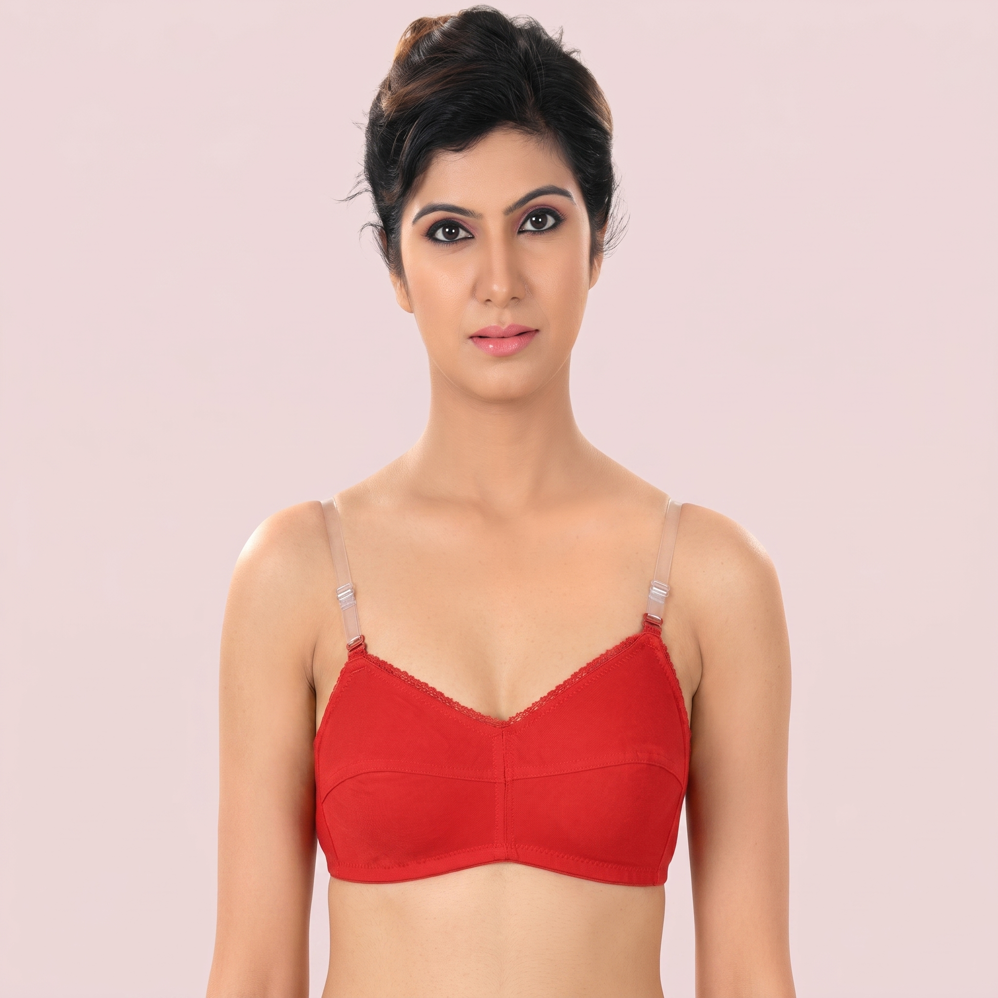 Woman wearing a red bralette against a light pink background