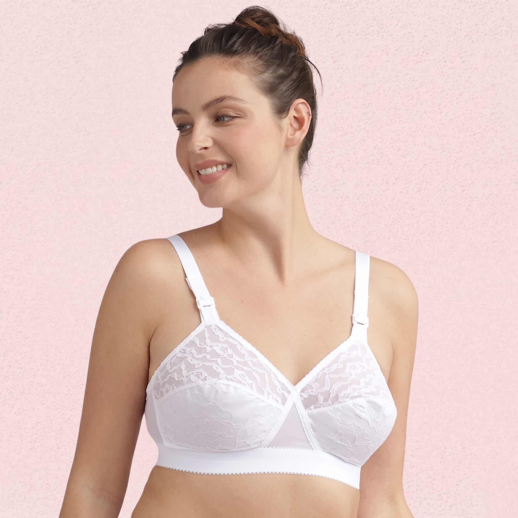 Woman wearing a white bra against a pink background