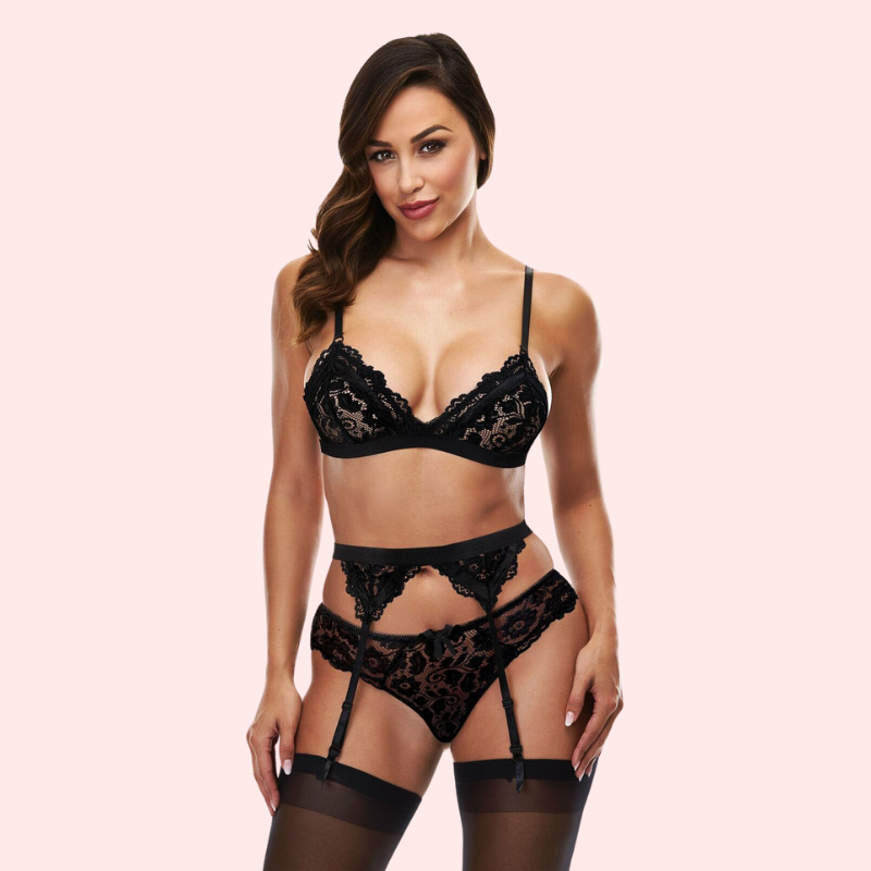 Woman wearing a black lace lingerie set on a plain background