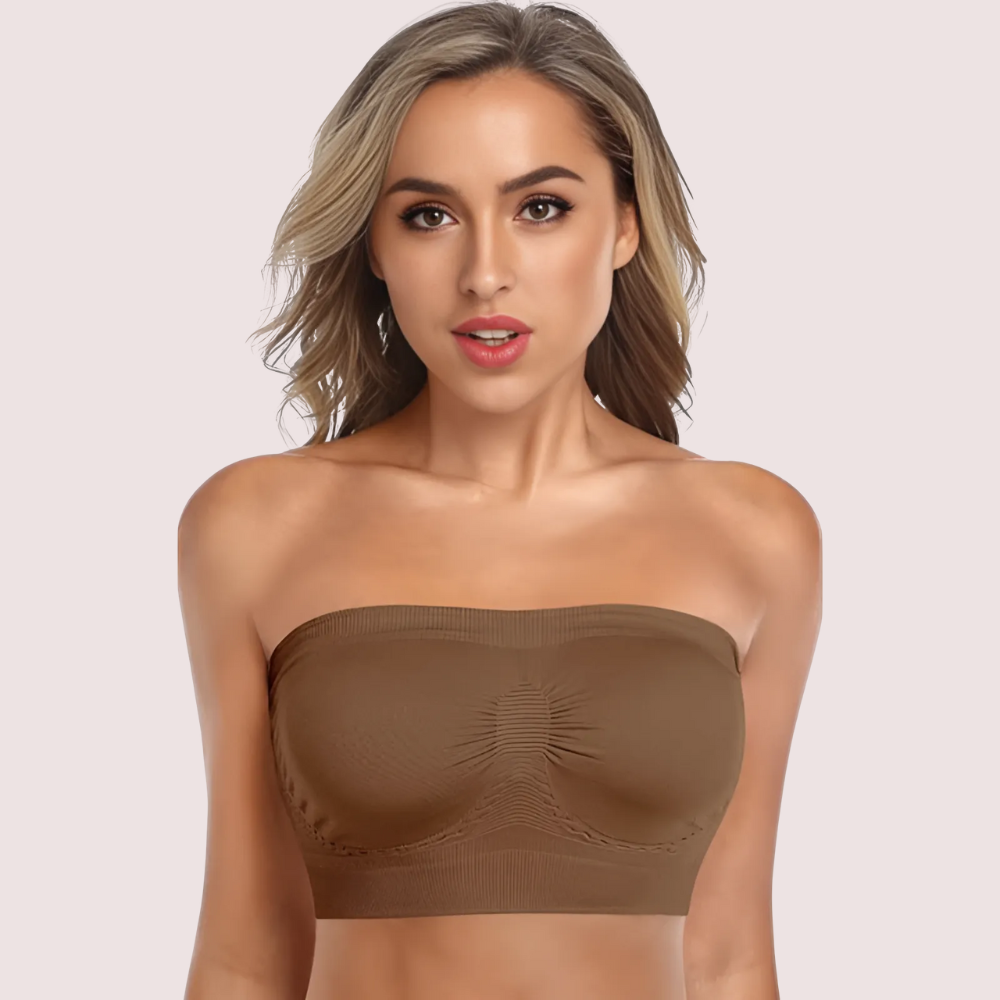 Woman wearing a brown strapless top against a light pink background