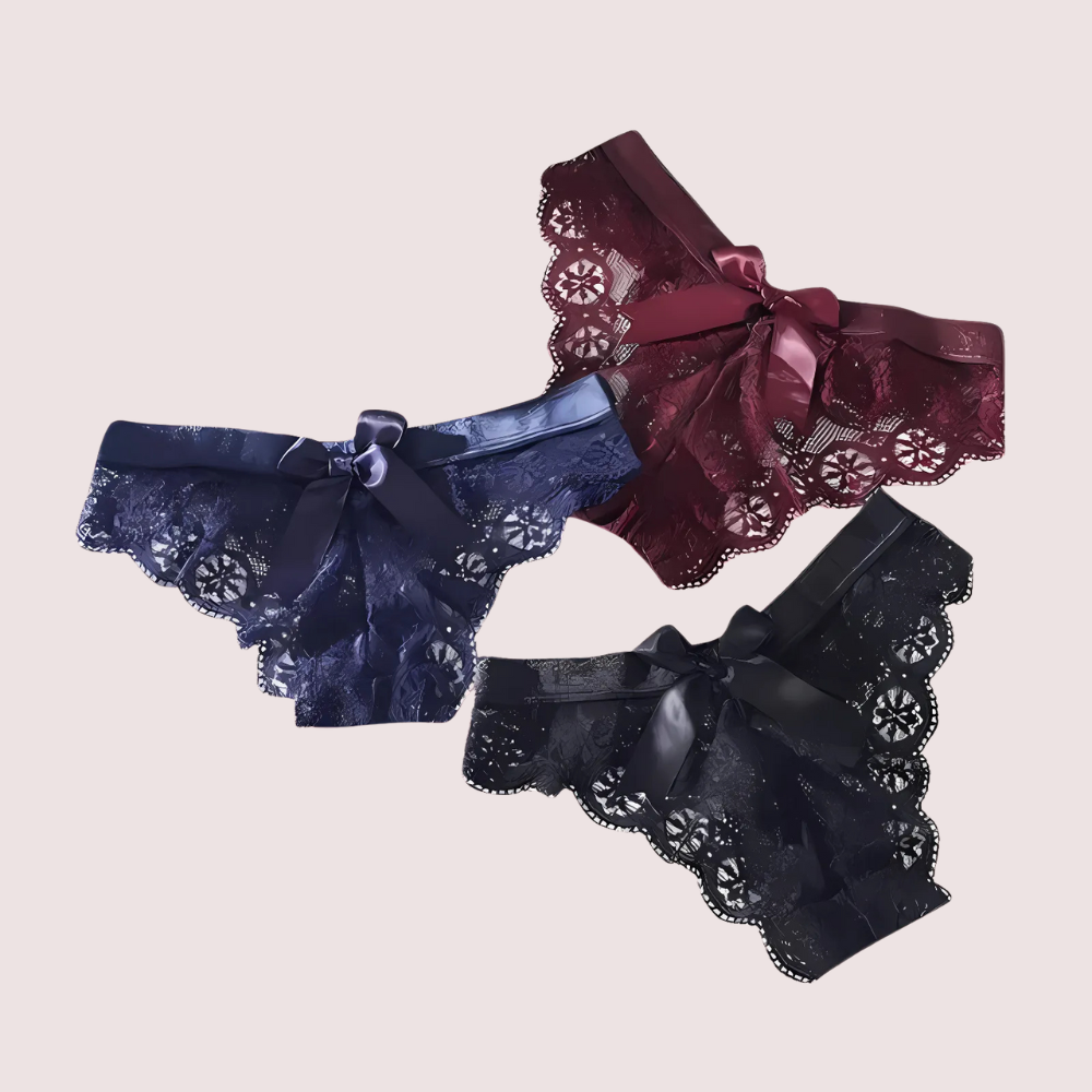 Three pairs of lace-trimmed panties in blue, red, and black on a beige background.