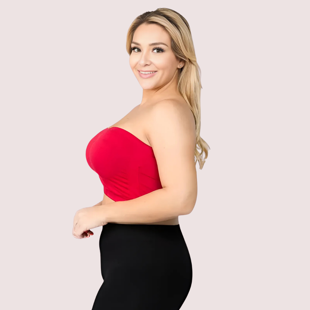 Woman wearing a red strapless top and black skirt on a light pink background
