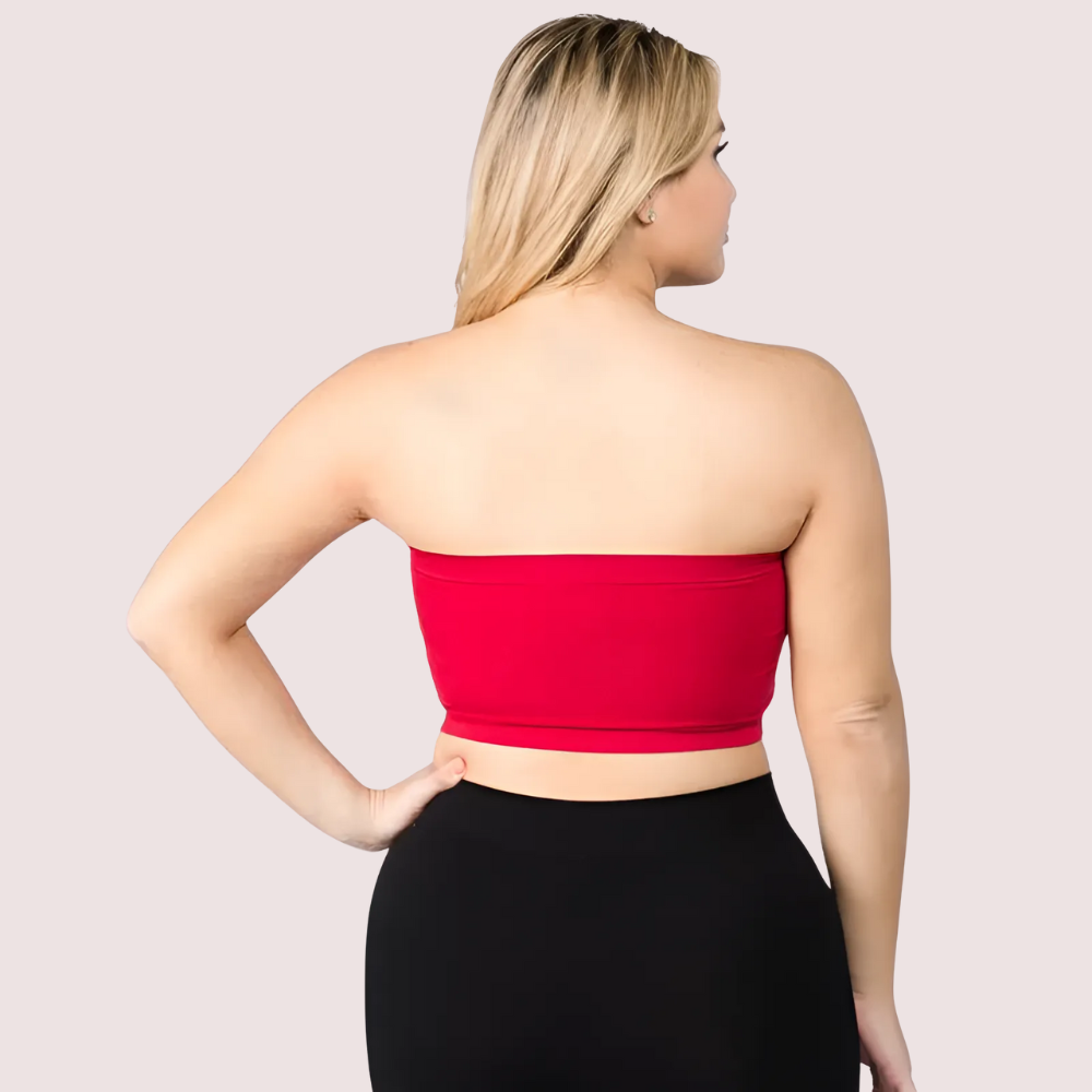 Woman wearing a red strapless top against a plain background