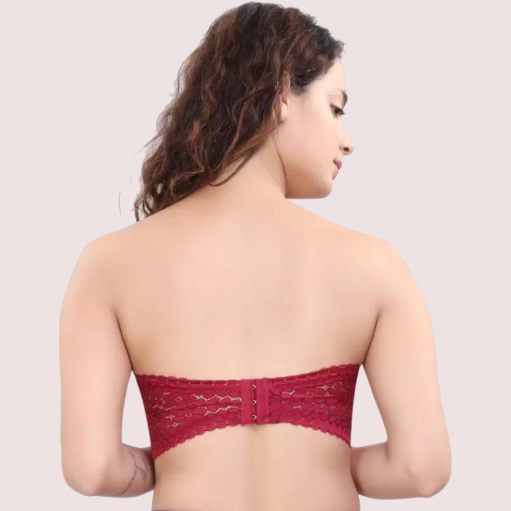 Woman wearing a red lace strapless top against a plain background