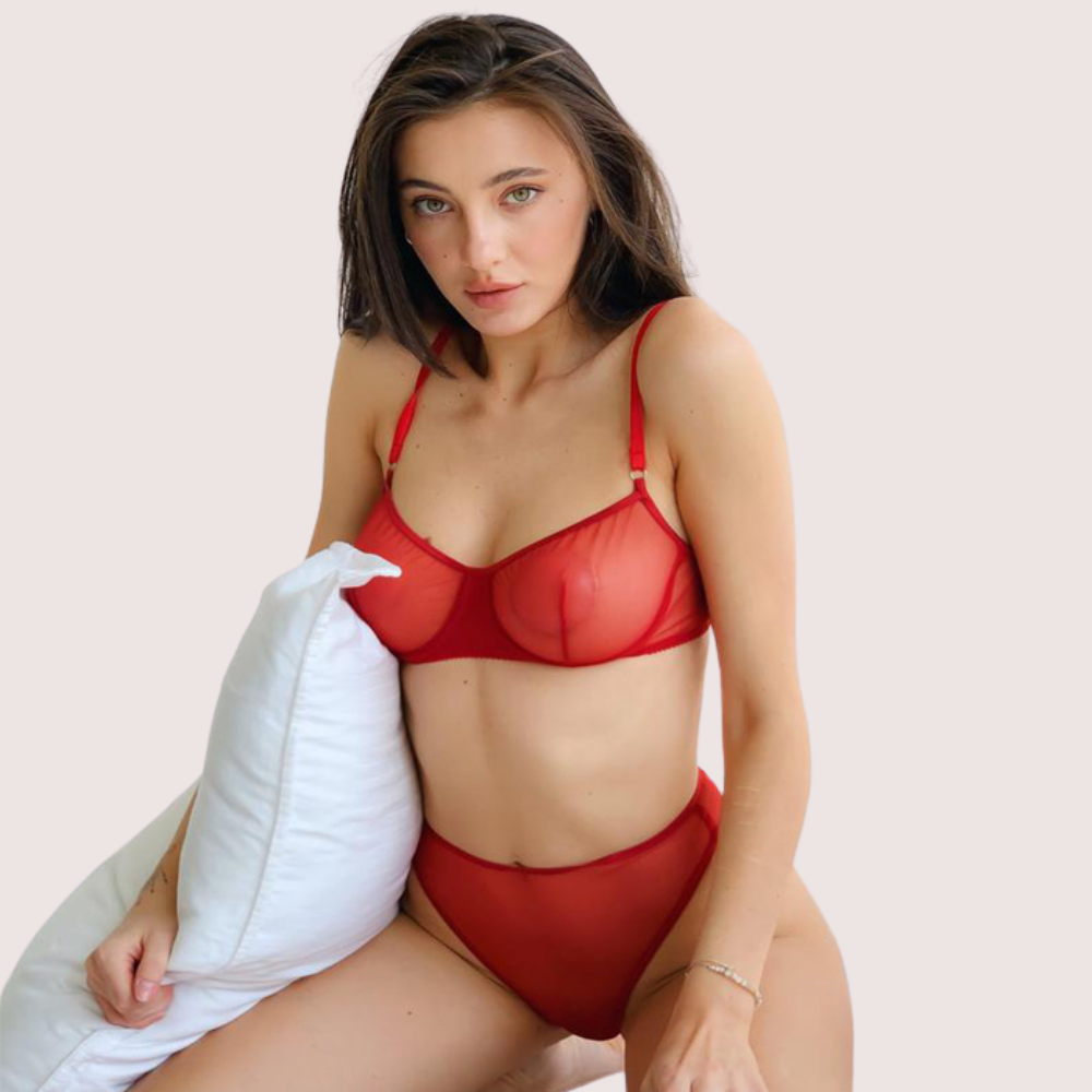 Woman wearing a red bra and panties set against a white background