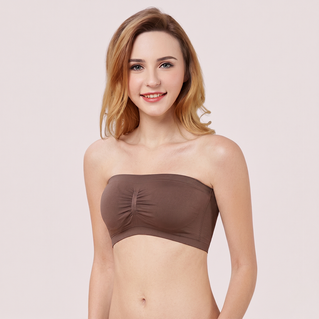 Woman wearing a brown strapless top against a light pink background