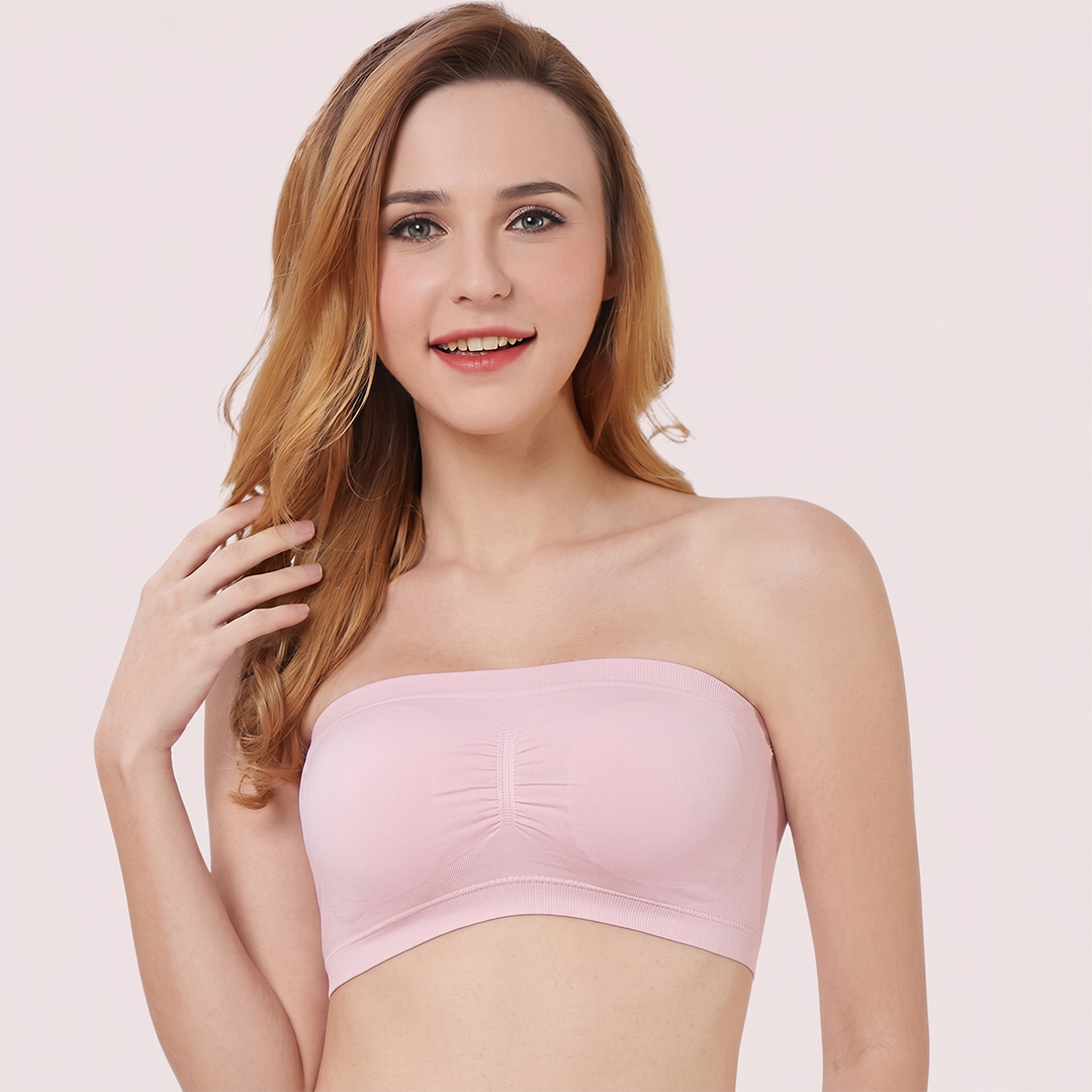 Woman wearing a pink strapless top against a light pink background