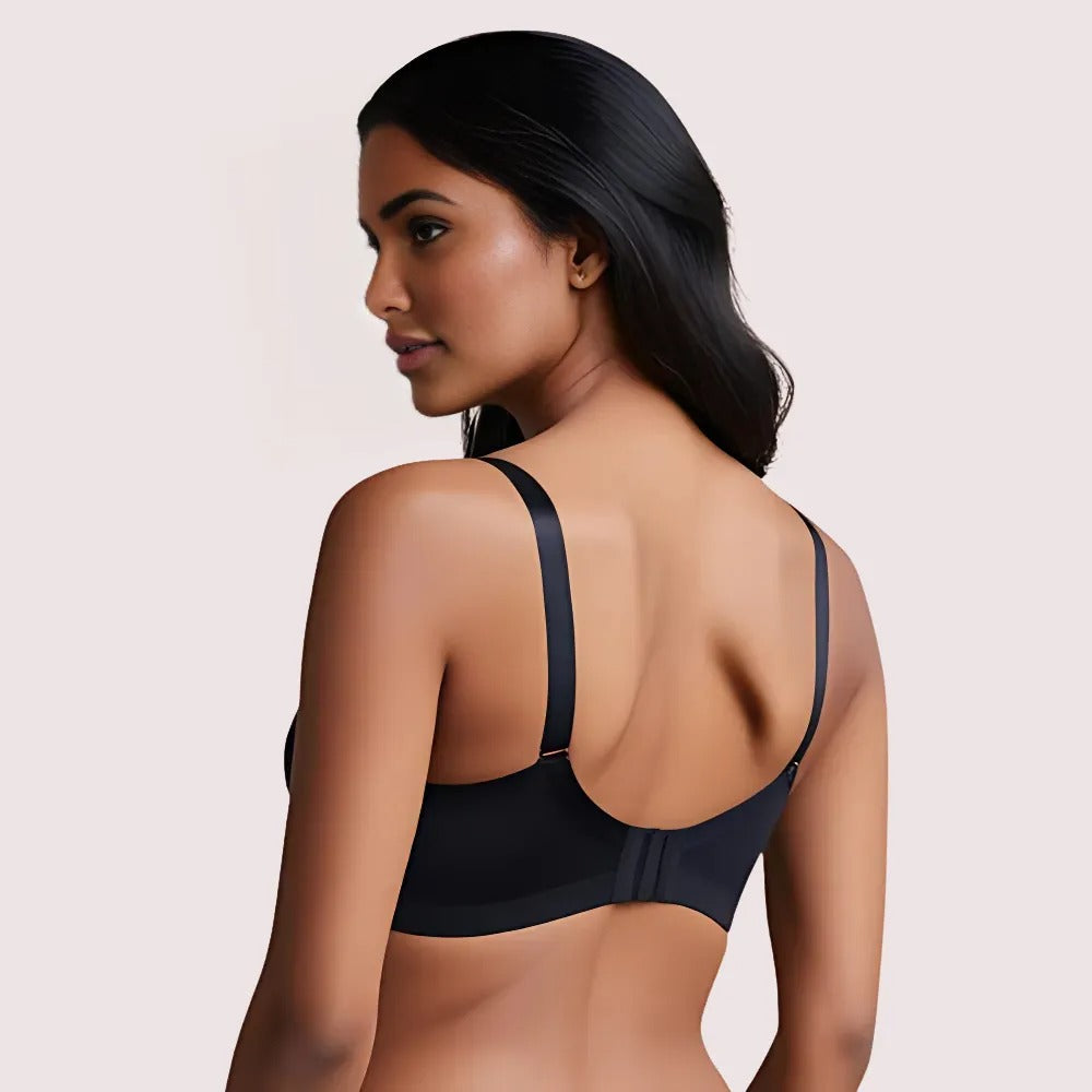 Woman wearing a black bralette against a beige background
