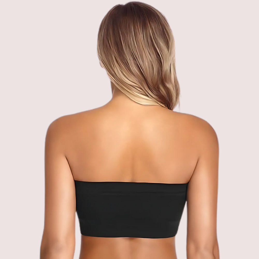 Person wearing a black strapless top on a plain background
