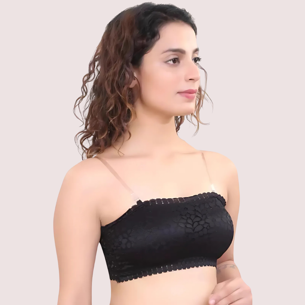Woman wearing a black lace top against a plain background