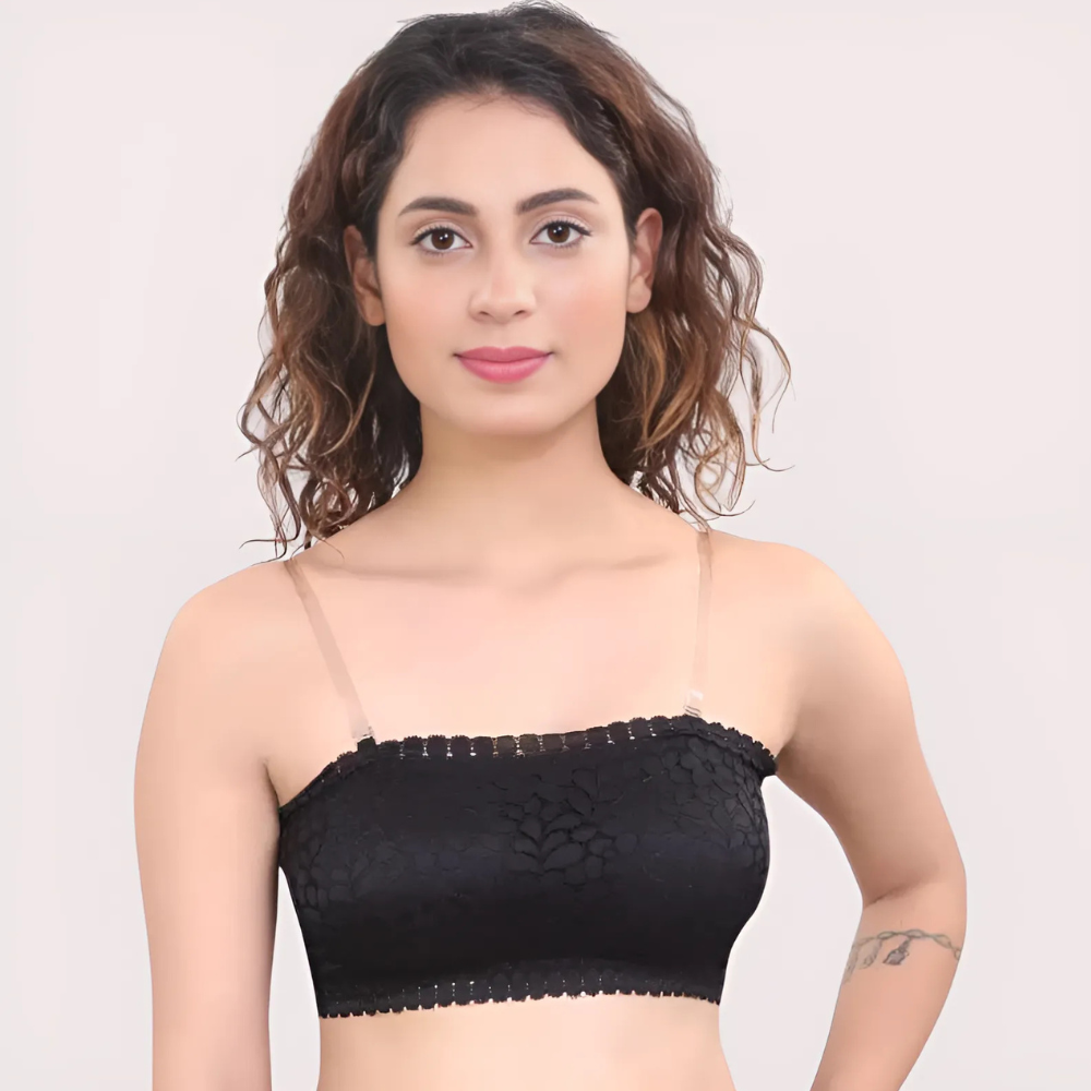 Woman wearing a black lace bralette against a plain background