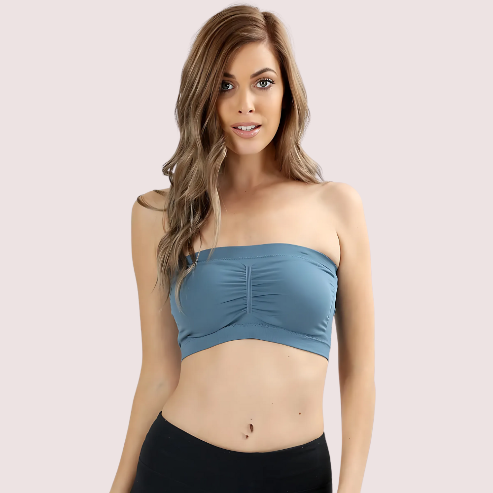Woman wearing a blue strapless top against a light pink background