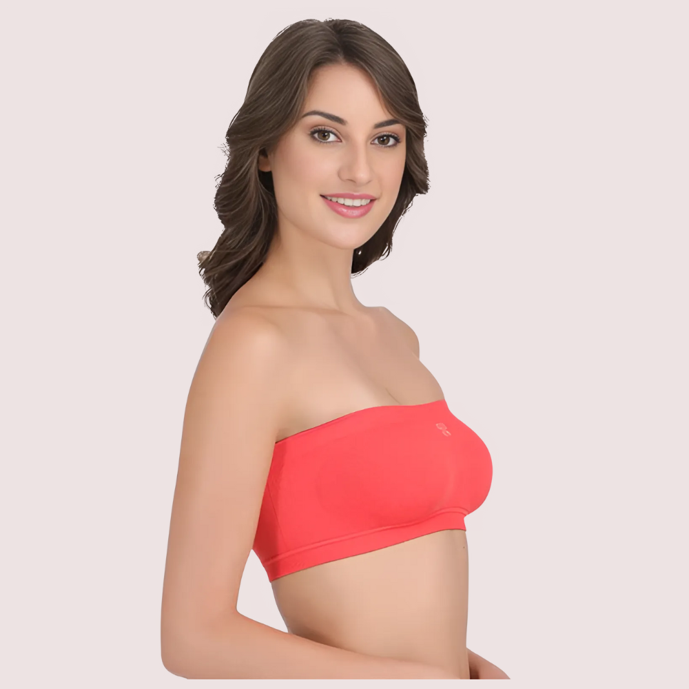 Woman wearing a red strapless top against a plain background