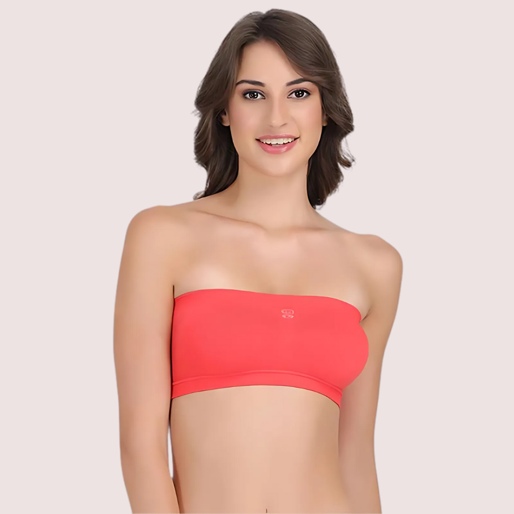 Woman wearing a red strapless top against a plain background