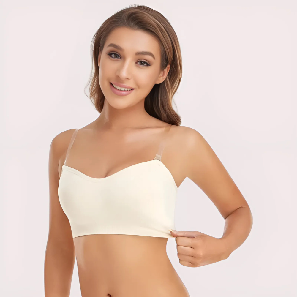 Woman wearing a beige bralette on a plain background