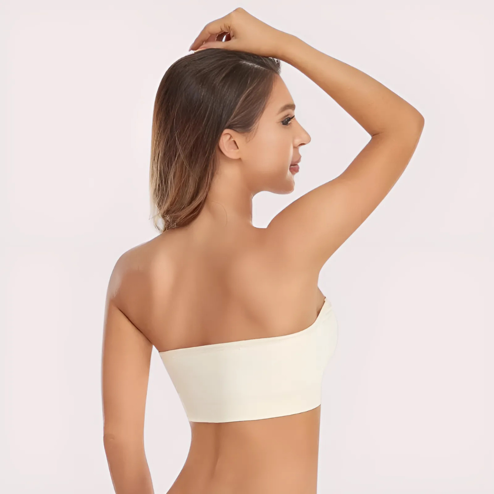 Woman wearing a white strapless top against a light background