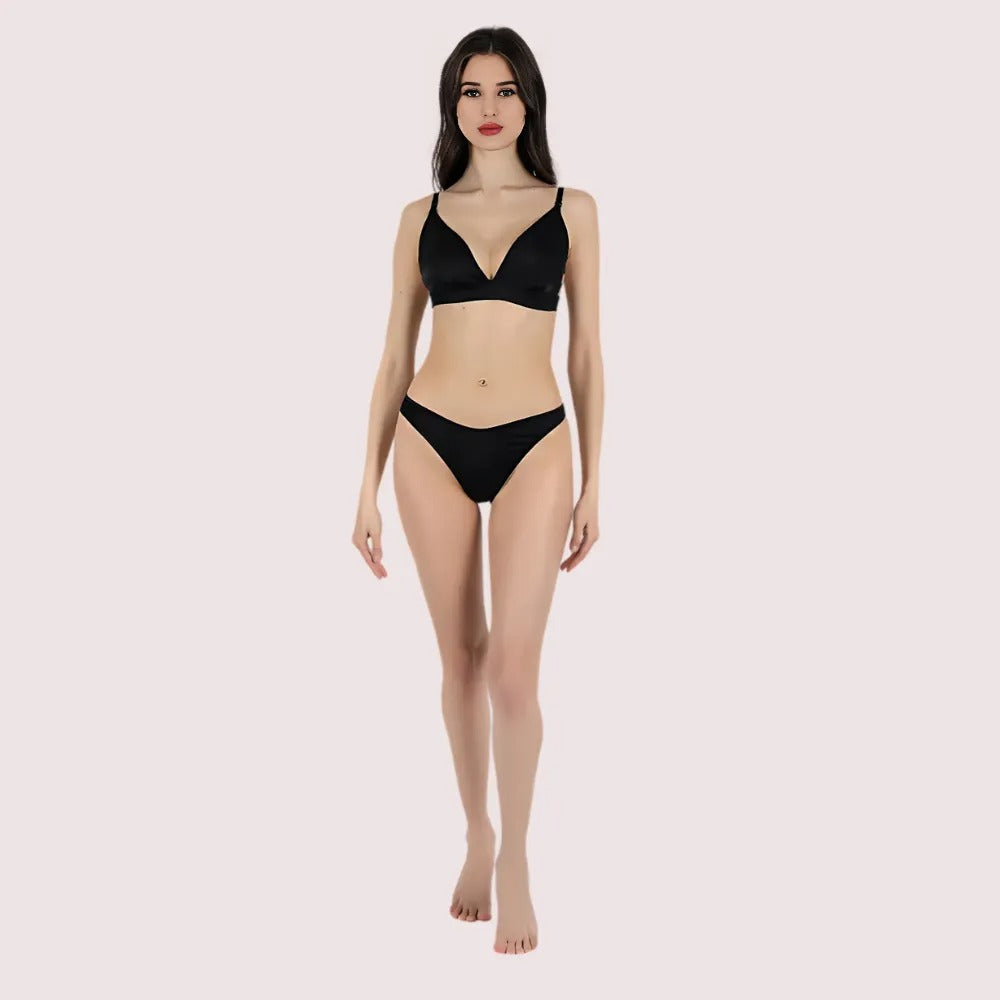 Woman wearing a black bikini set on a light pink background