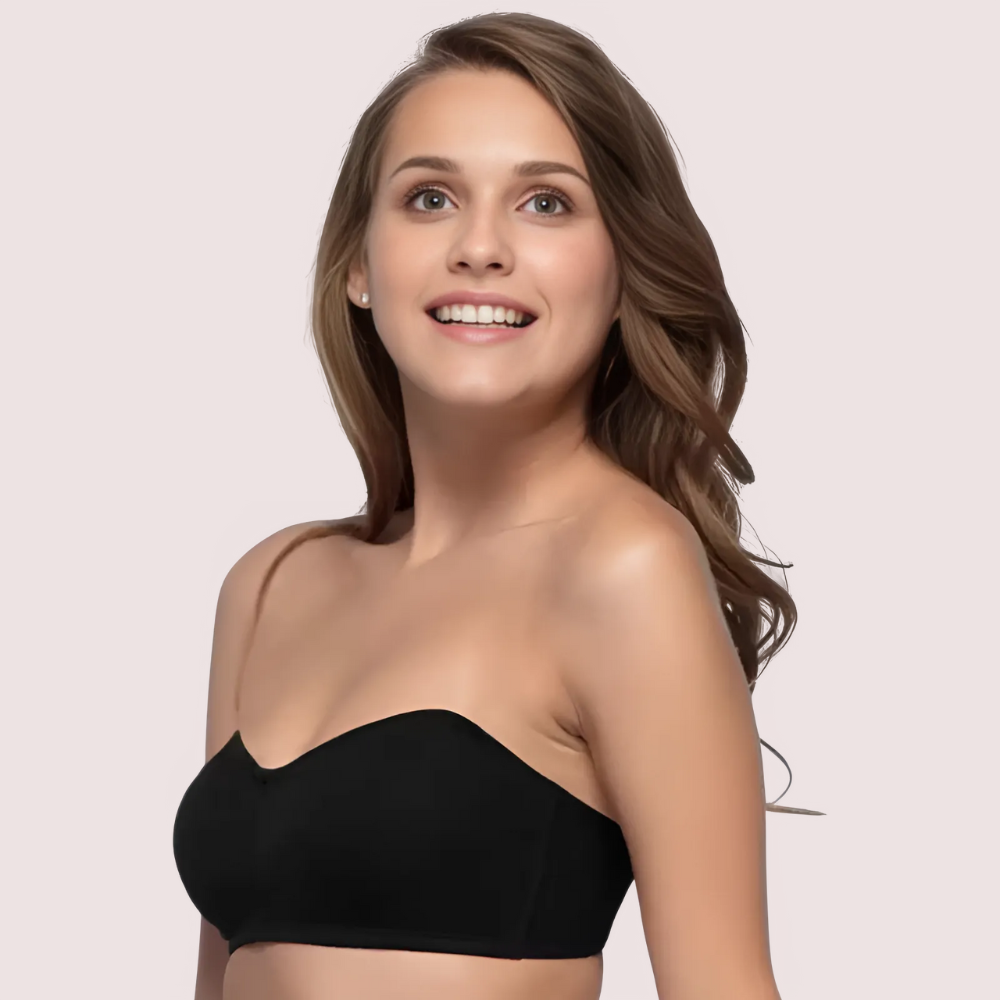 Woman wearing a black strapless top against a light pink background